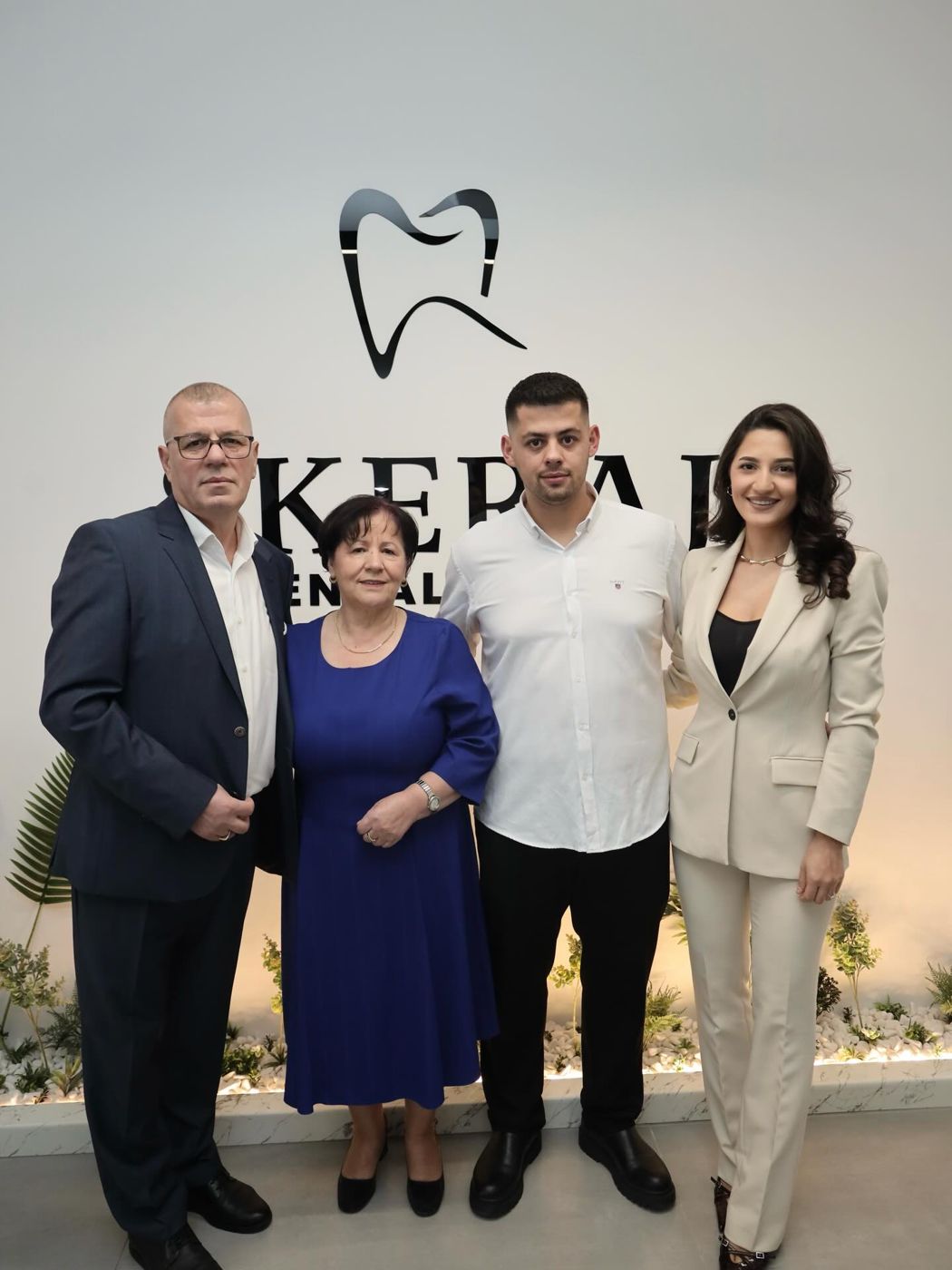 Ekipi dhe të afërmit para logos së SKERAJ Dental Clinic në ditën e hapjes